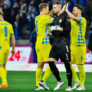 Lennart Grill geht enttäuscht über den Platz, Spieler der Eintracht Braunschweig klatschen sich im Hintergrund ab