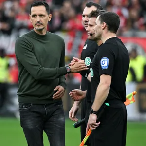 Trainer Dino Toppmöller gibt Schiedsrichter Dr. Felix Brych die Hand und schaut dabei weg