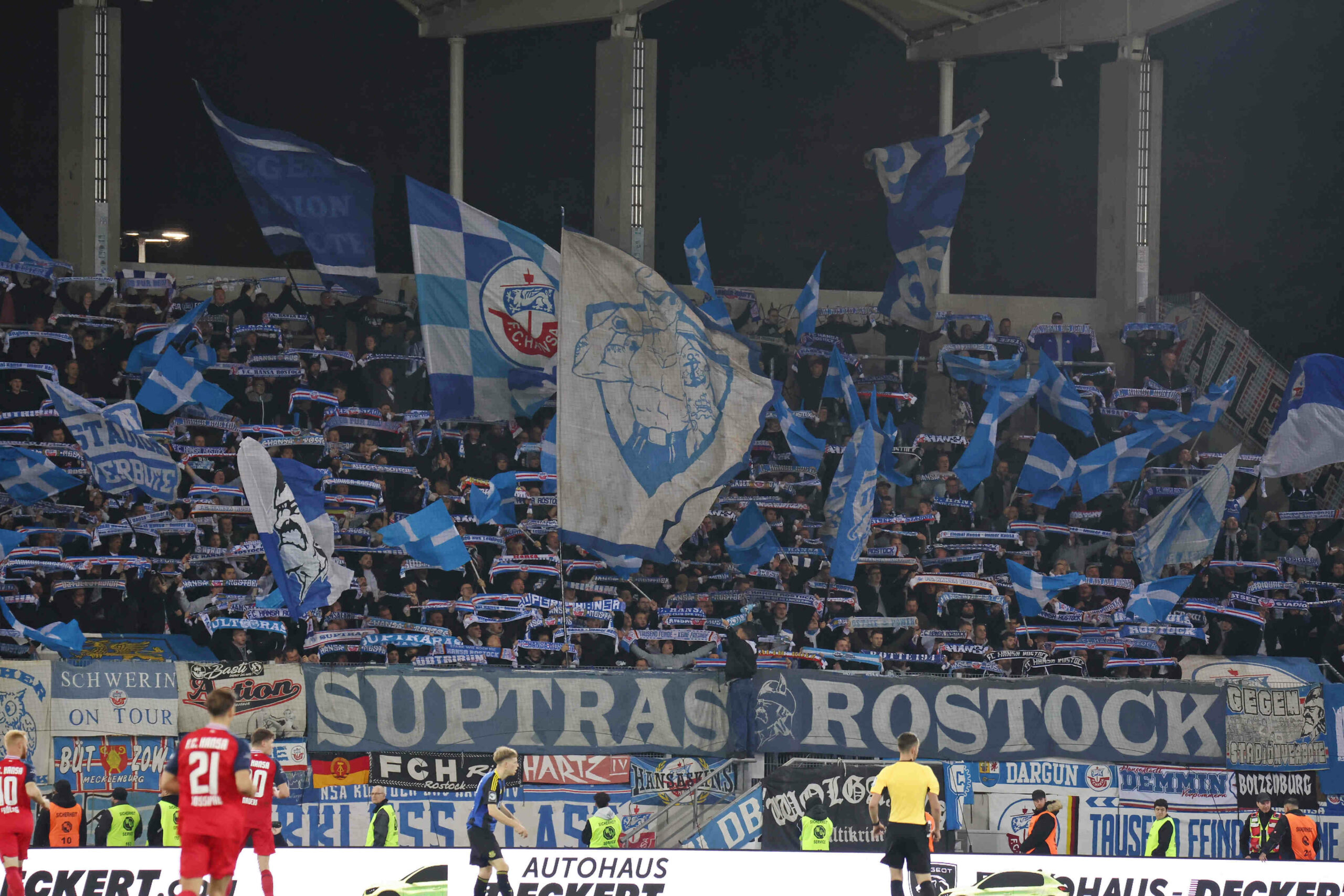 Tribüne mit Fans von Hansa Rostock, welche ihre Schals hochhalten