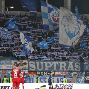 Tribüne mit Fans von Hansa Rostock, welche ihre Schals hochhalten