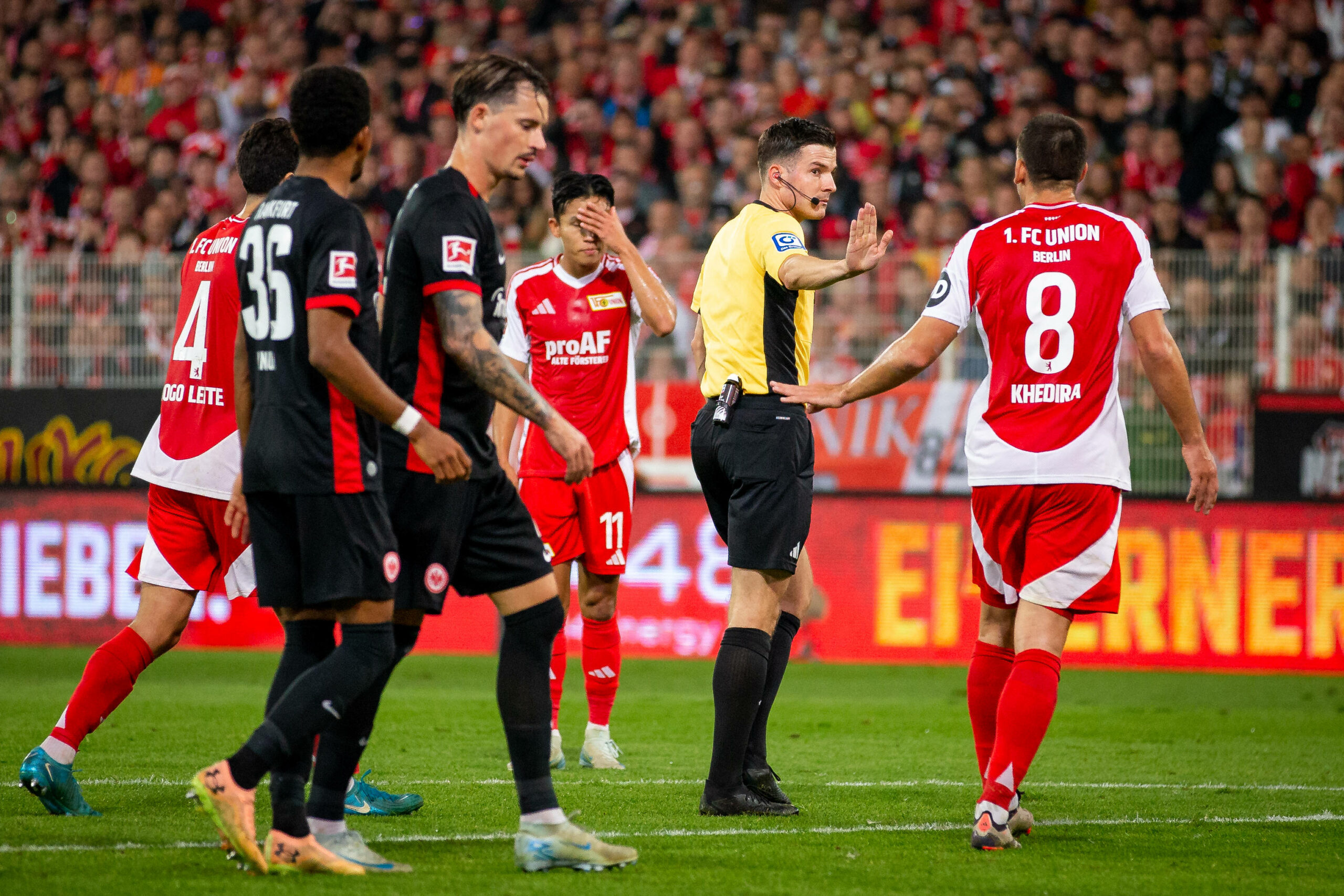 Schiedsrichter Harm Osmers wird von Spielern von Union Berlin bedrängt.