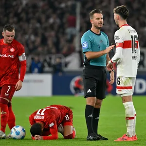 Schiedsrichter Daniel Schlager im Gespräch mit Atakan Karazor, Frans Kraetzig und Marlon Ritter stehen daneben; Kenny-Prince Redondo liegt verletzt am Boden