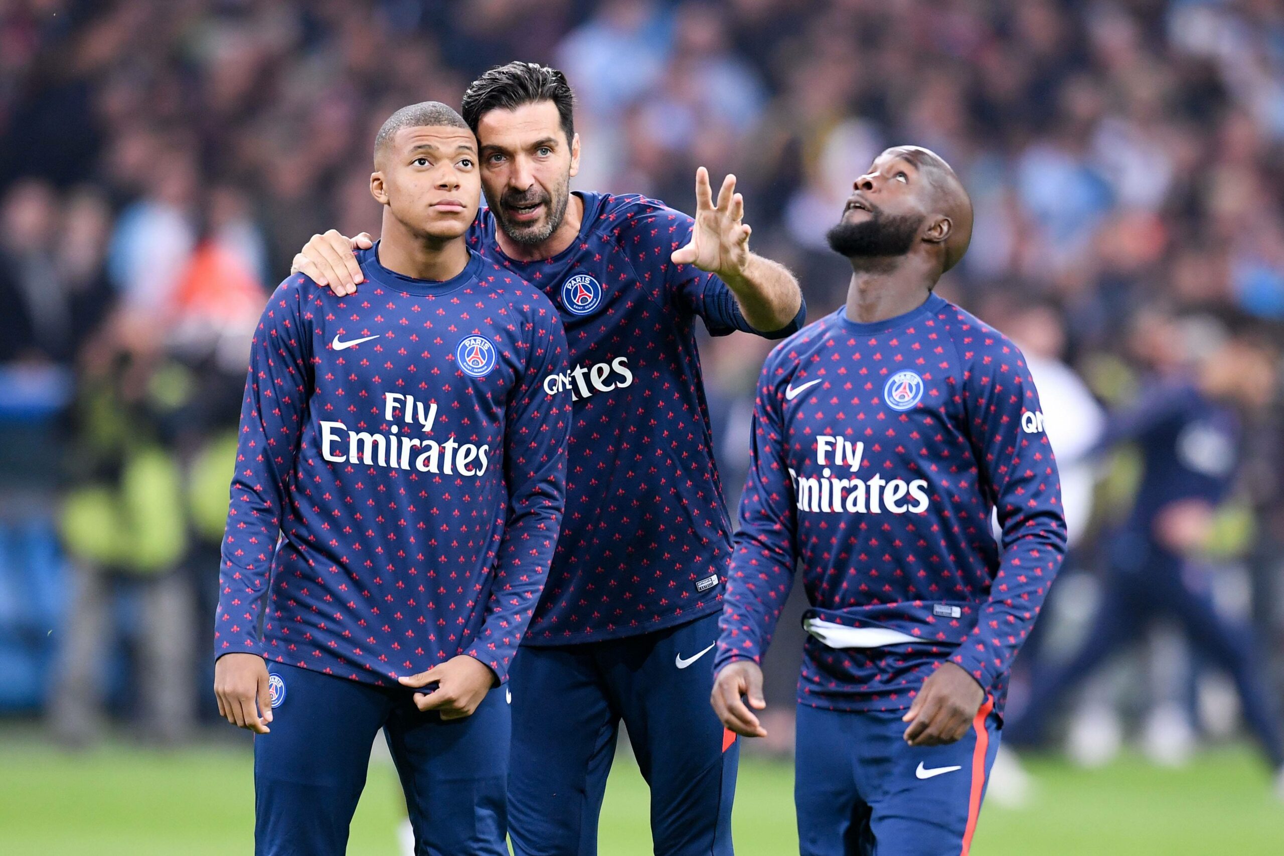 Gianluigi Buffon unterhält sich mit Kylian Mbappe, während Lassana Diarra an ihnen vorbei geht