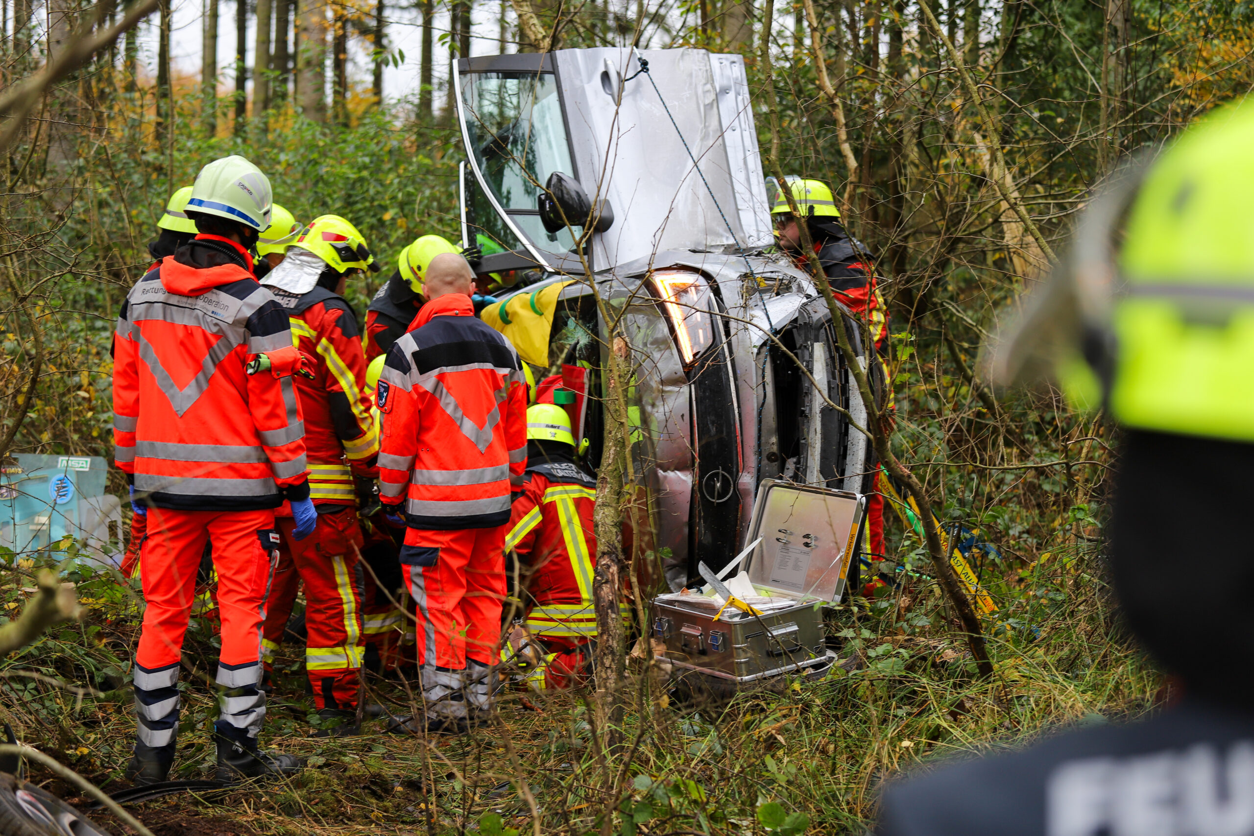 Rettungskräfte an einem auf der Seite liegenden Auto