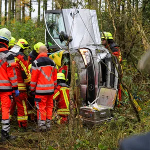 Rettungskräfte an einem auf der Seite liegenden Auto