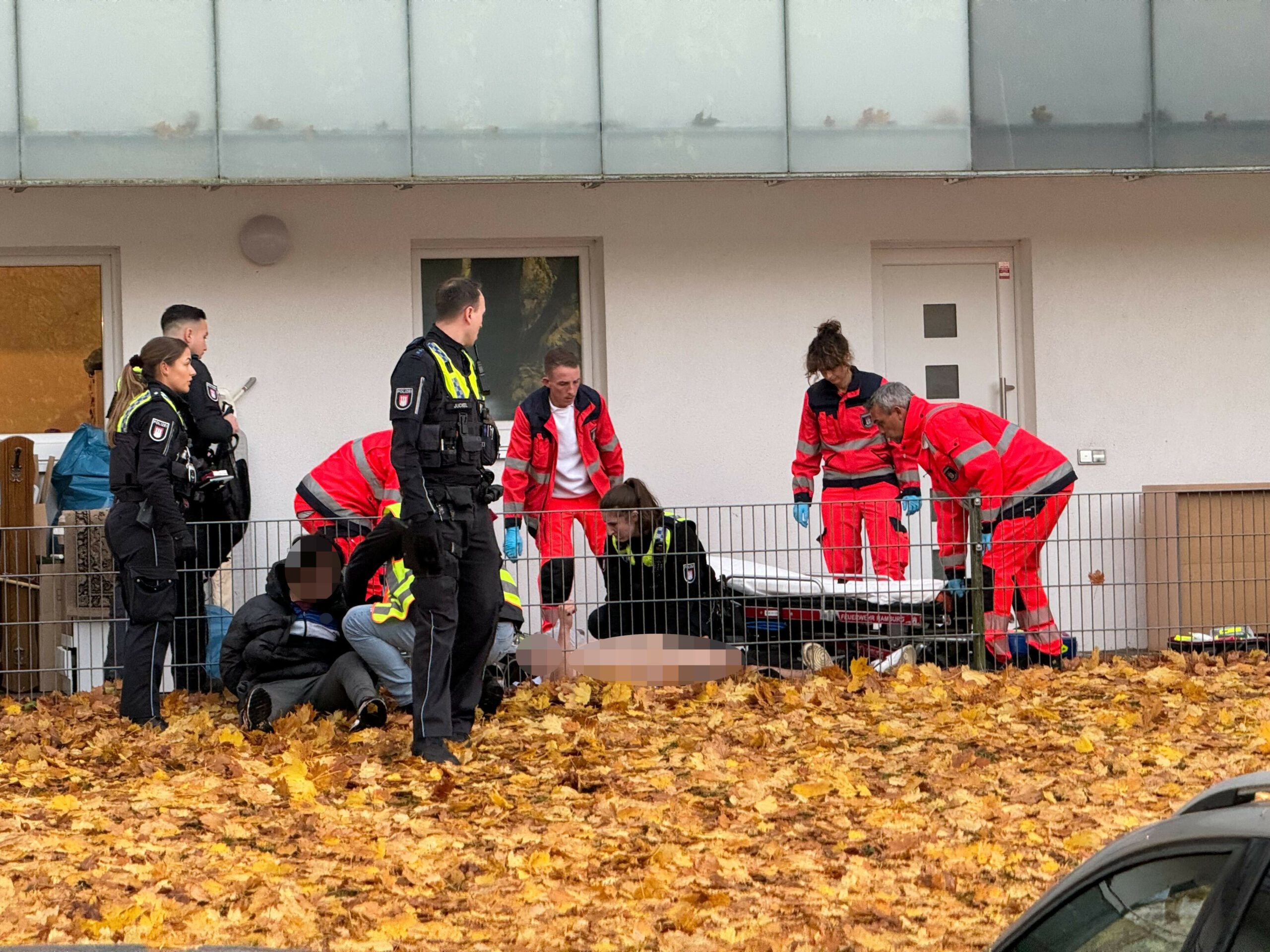 Nach der Messerstecherei auf der Straße Berner Koppel: Sanitäter versorgen den verletzten Jugendlichen, Polizeikräfte nehmen den Tatverdächtigen fest.