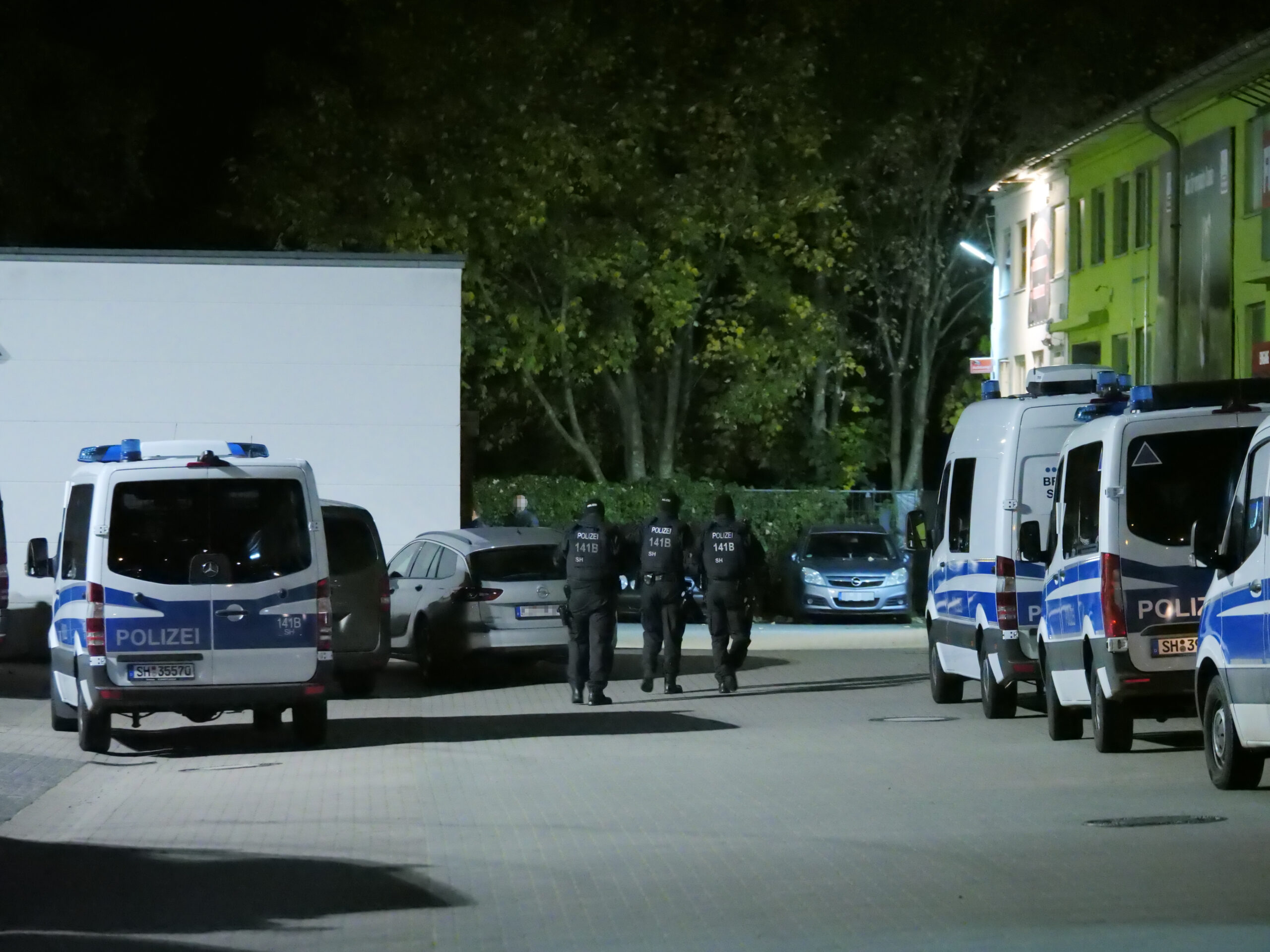 Einsatzkräfte auf dem Weg zum Clubheim der „Red Devils“ in Neumünster.