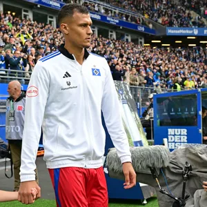 Davie Selke läuft mit einem kleinen Jungen an der Hand ins Volksparkstadion ein