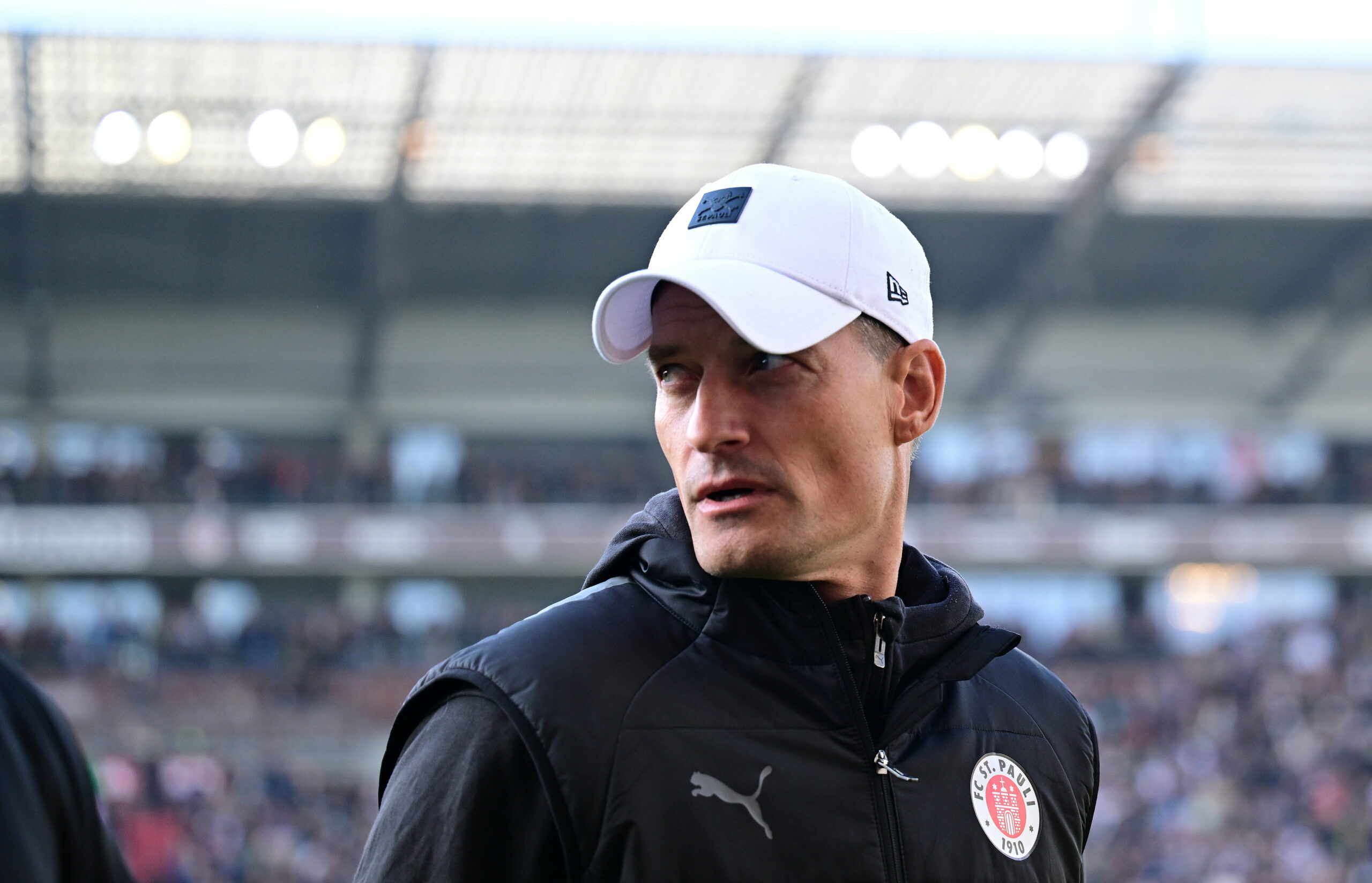 St. Pauli-Trainer Alexander Blessin mit weißer Cap auf dem Kopf beim Spiel gegen Wolfsburg.