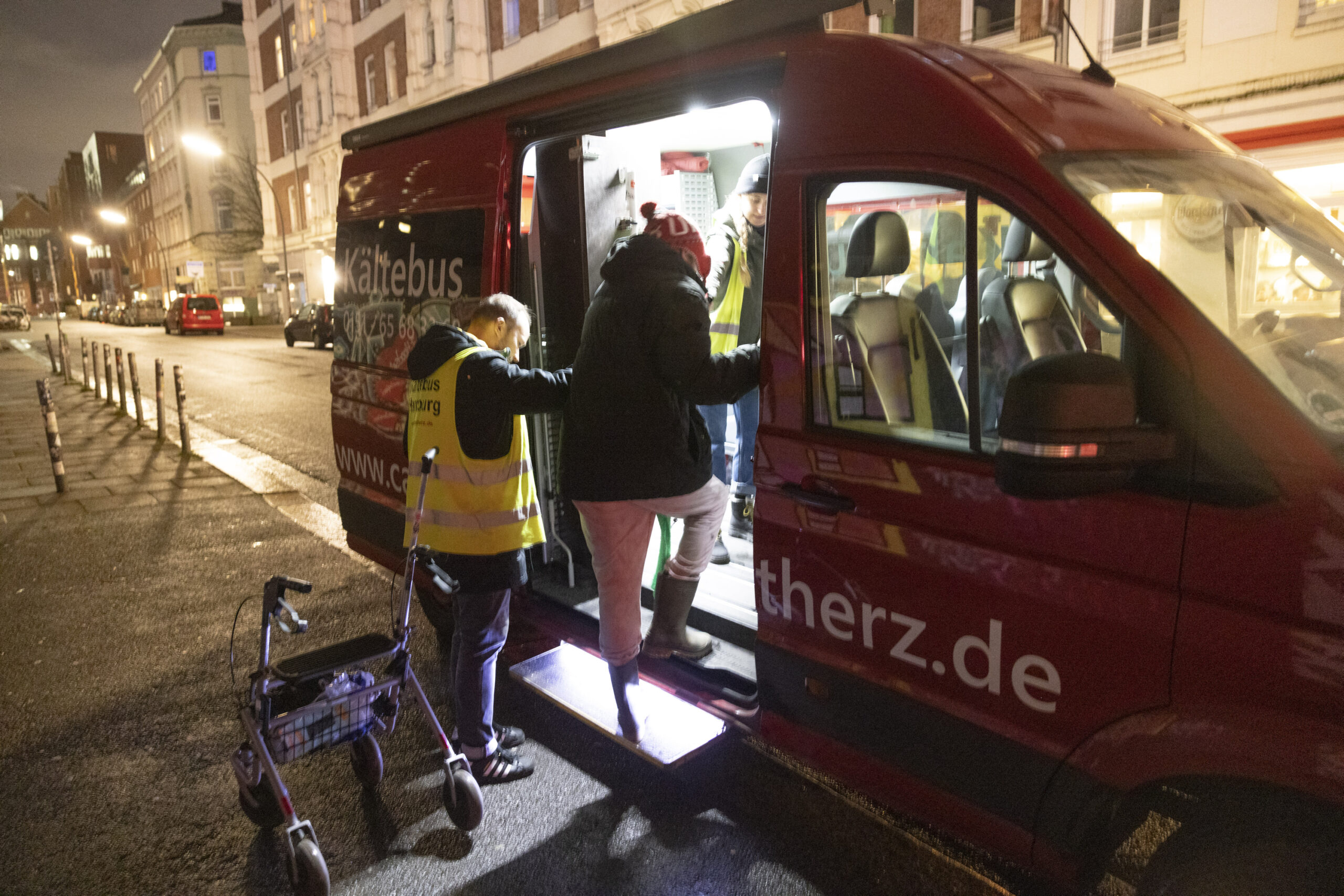 Mensch steigt in einen roten Bus mit der Aufschrift „Kältebus“ ein