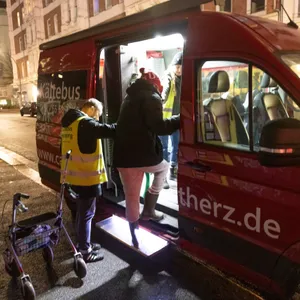 Mensch steigt in einen roten Bus mit der Aufschrift „Kältebus“ ein