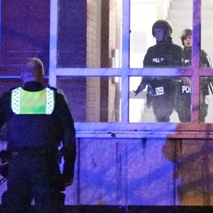 Schwer bewaffnete Polizisten in Schutzkleidung im Treppenhaus an der Ahrensburger Straße.