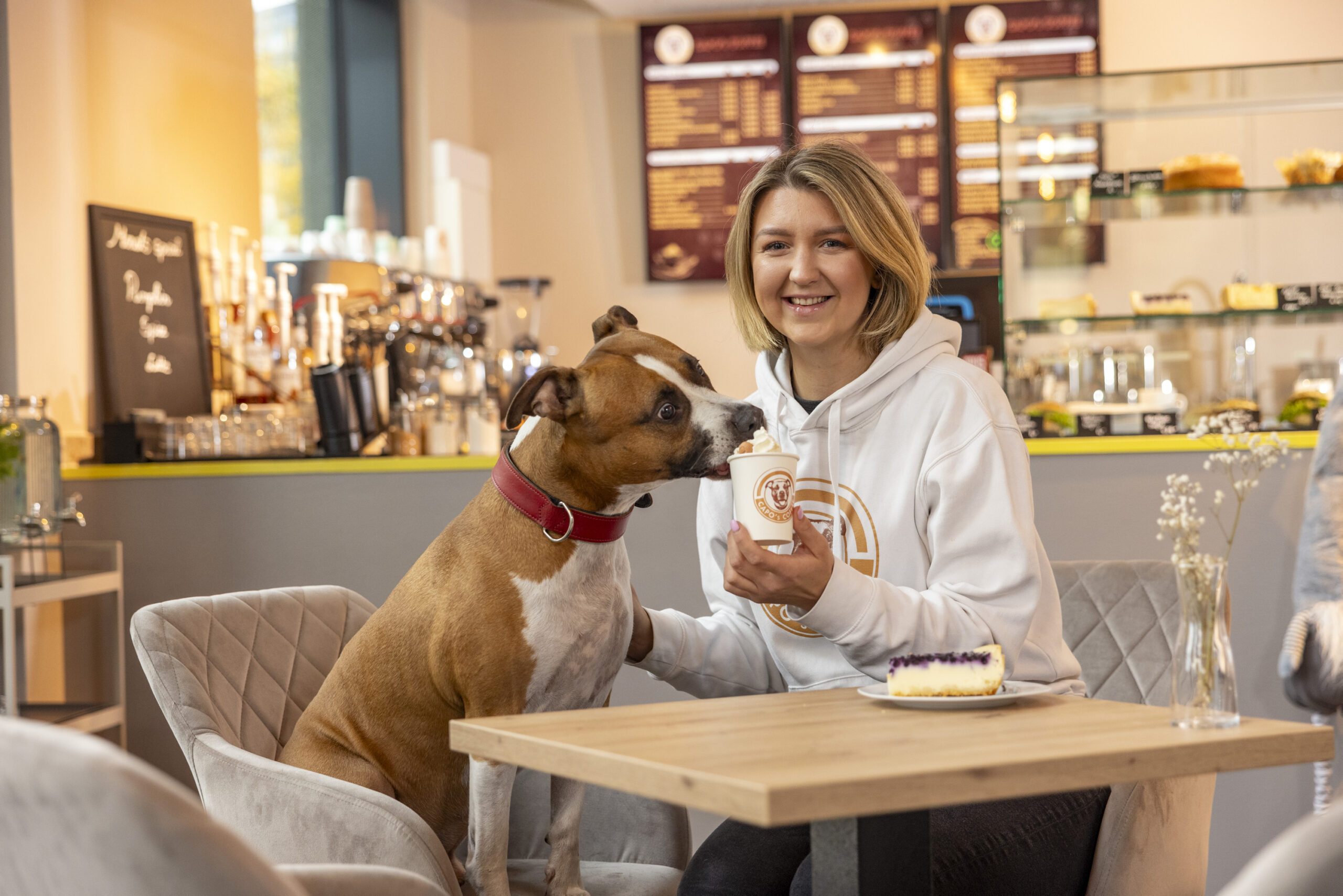 Sandra Bagociunaite (28) serviert Mischling Capo (8) einen Hunde-Cappuccino in ihrem Café in der HafenCity.