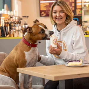 Sandra Bagociunaite (28) serviert Mischling Capo (8) einen Hunde-Cappuccino in ihrem Café in der HafenCity.