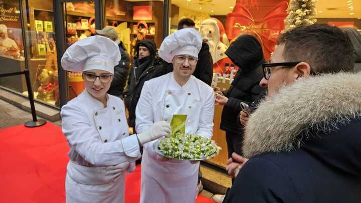 „Lindt“-Mitarbeiter servieren Schoko-Happen für die Wartenden.