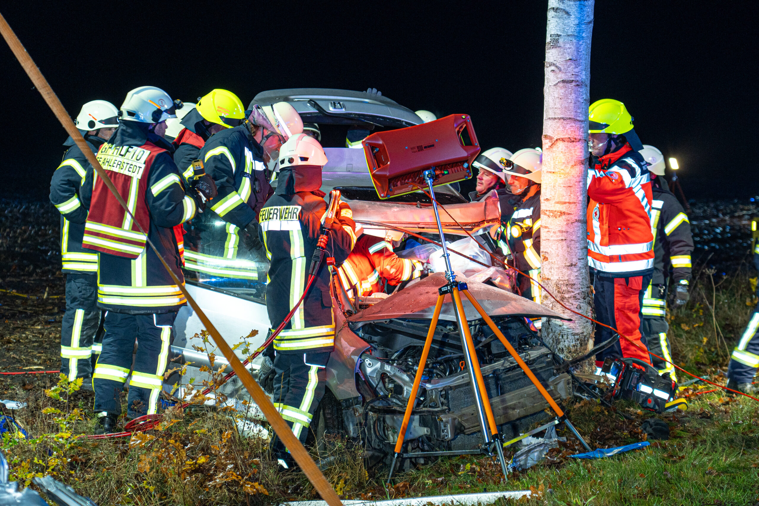 Feuerwehrleute umringen während der Rettungsmaßnahmen den zerstörten Honda.