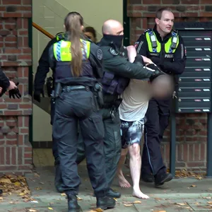 Der Mann wurde mit Handschellen abgeführt und später auf der Trage fixiert.