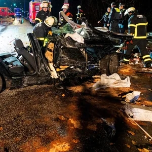 Der zerstörte BMW und rechts das Wohnwagenwrack nach dem Unfall auf dem Reinbeker Redder in Hamburg-Lohbrügge.