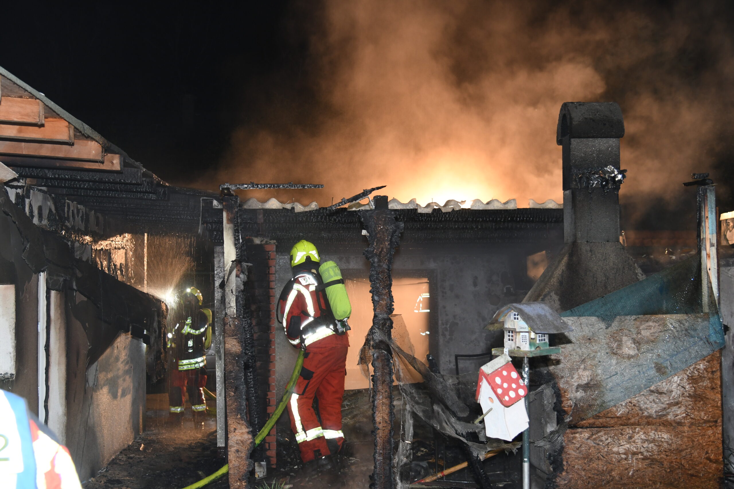 Feuerwehrkräfte löschen den brennenden Schuppen.