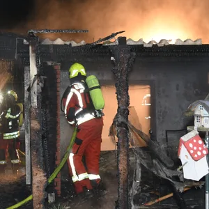 Feuerwehrkräfte löschen den brennenden Schuppen.