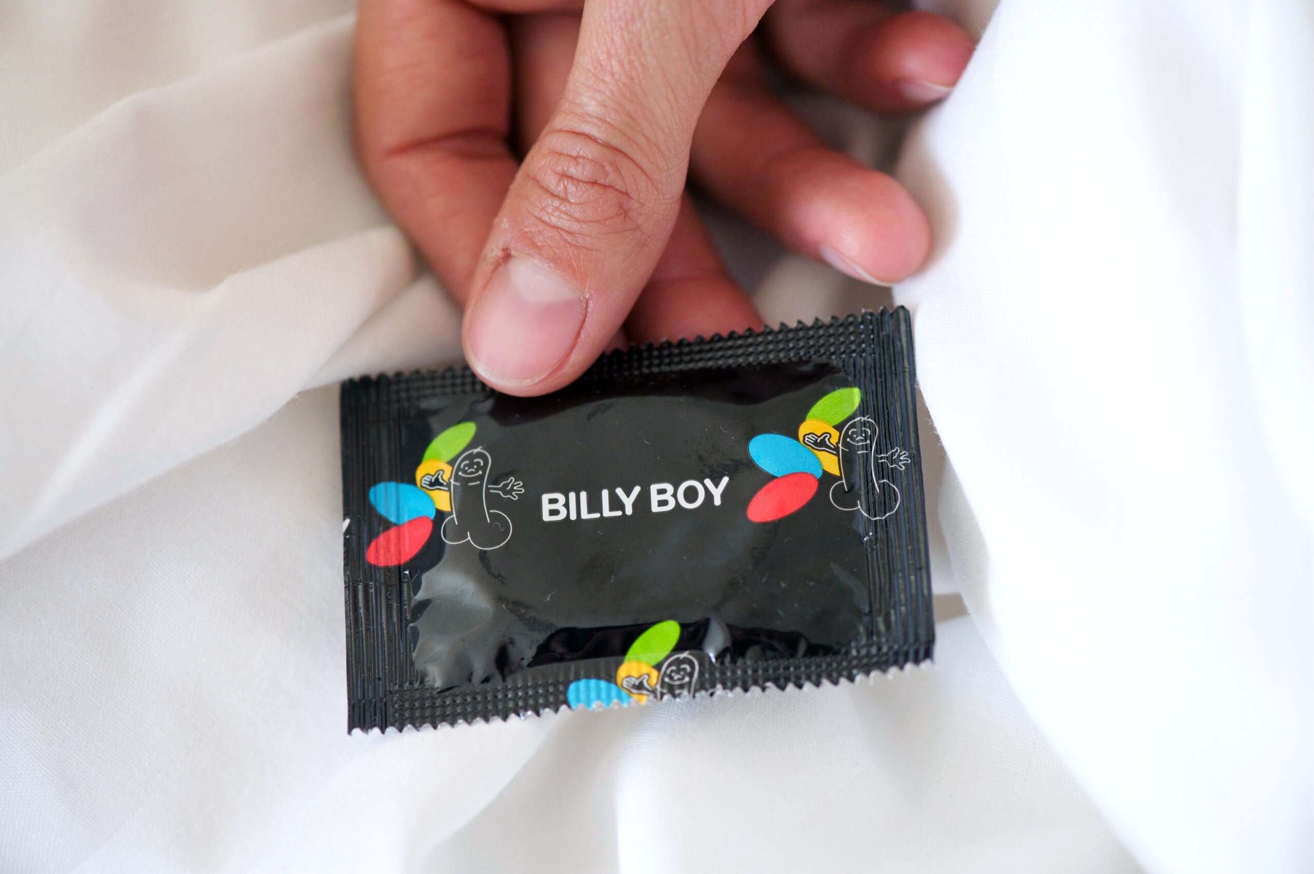 Die Verpackung eines Kondoms von Billy Boy wird in die Kamera gehalten