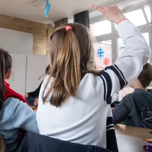 Schüler einer fünften Klasse eines Gymnasiums melden sich im Unterricht.