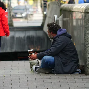 Ein bettelnder Mann sitzt am Eingang einer U-Bahn-Station