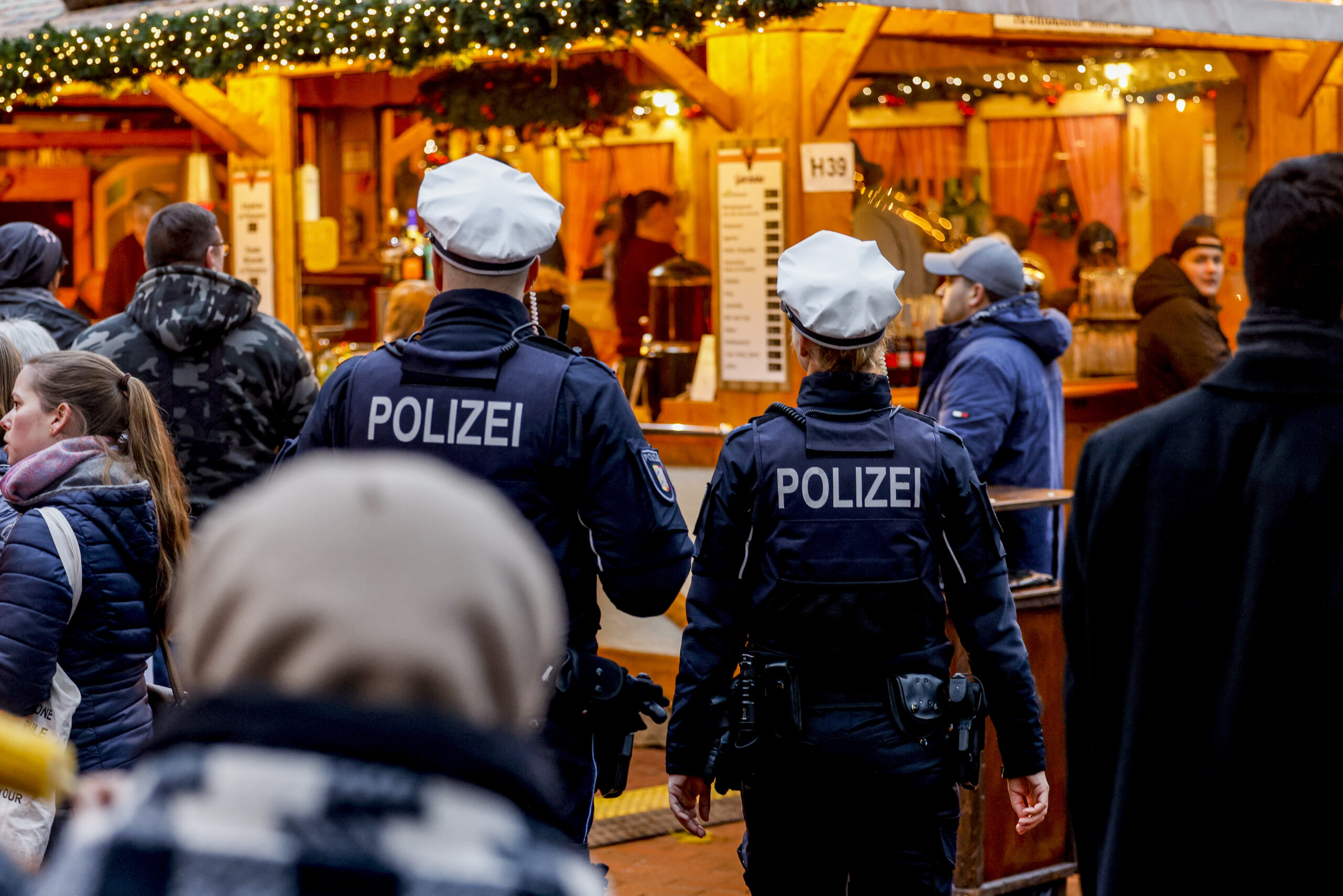 Polizisten gehen über den Weihnachtsmarkt in der Kieler Innenstadt.