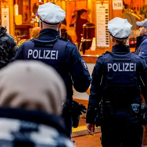 Polizisten gehen über den Weihnachtsmarkt in der Kieler Innenstadt.