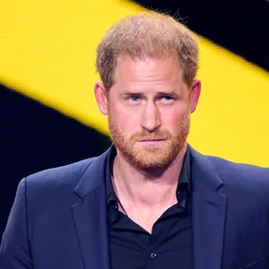 Rothaariger junger Mann mit Bart vor schwarz-gelbem Hintergrund
