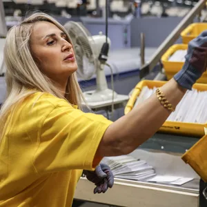 Eine Mitarbeiterin der Deutschen Post DHL sortiert Briefe im Briefverteilzentrum.
