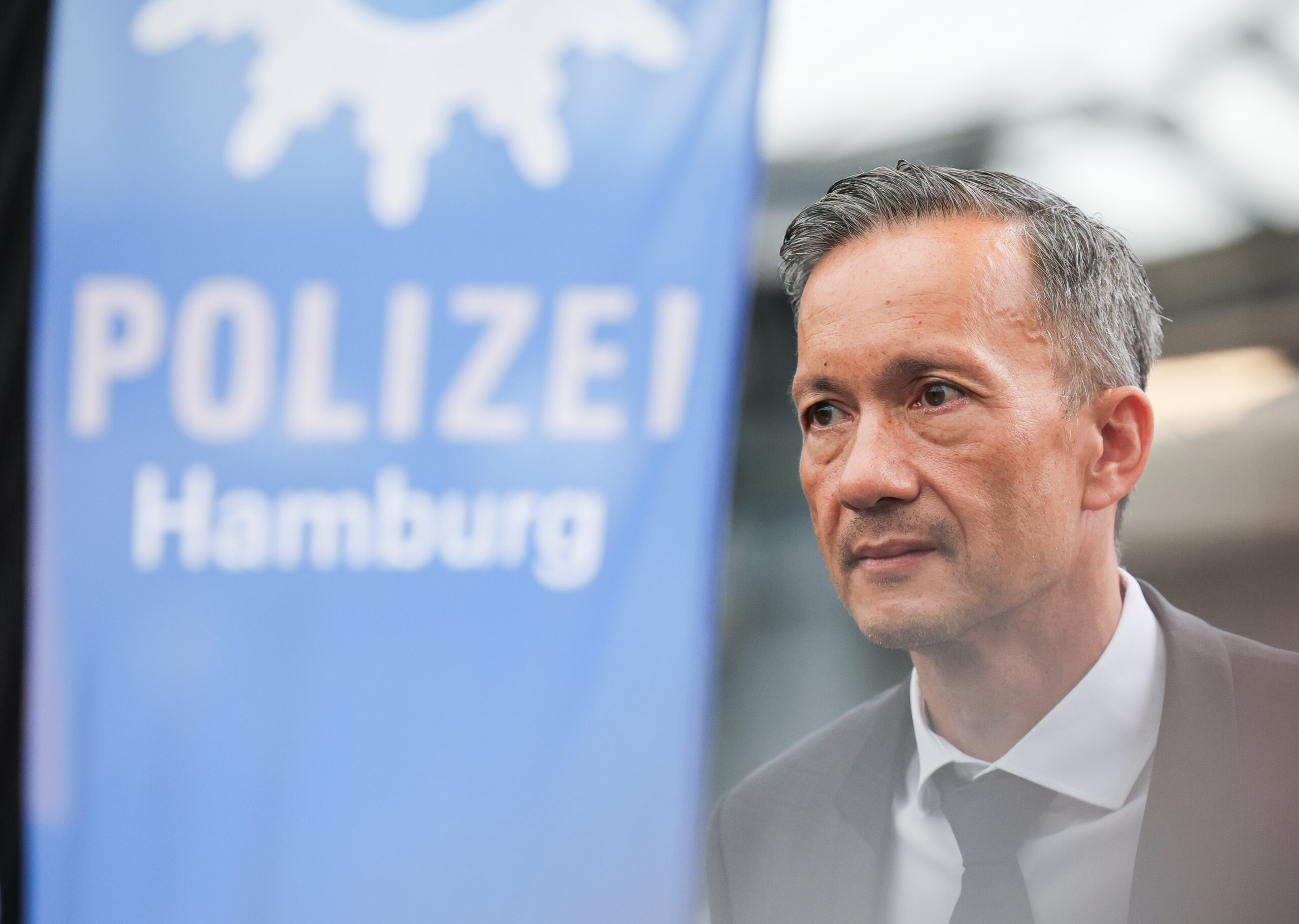 Mann vor Fahne: „Polizei Hamburg“