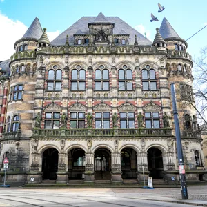 Das Landgericht Bremen von außen. Ein altes Gebäude mit zwei Türmen an den Seiten und großen Fenstern.