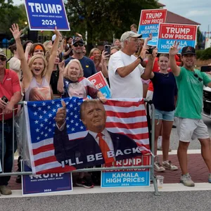 Menschen Jubeln mit Trump Plakaten am Straßenrand