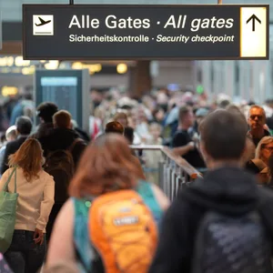 Flugpassagiere gehen zur Sicherheitskontrolle im Hamburg Airport.