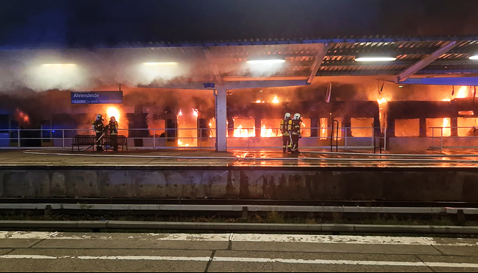 Einsatzkräfte der Feuerwehr löschen den Brand eines Zuges im S-Bahnhof Ahrensfelde.