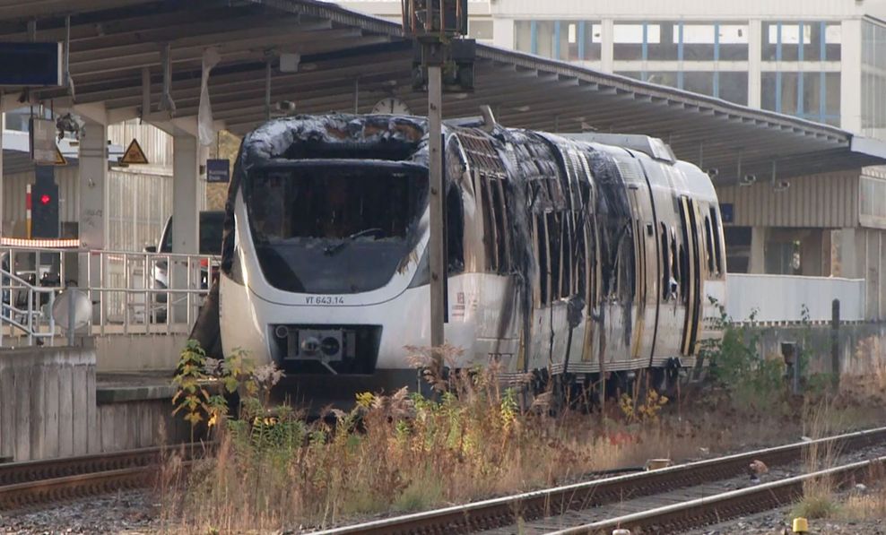 Ein ausgebrannter Zug der privaten Niederbarnimer Eisenbahn (NEB) steht im S-Bahnhof.