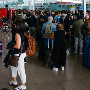 Dutzende von Menschen stehen auf dem Flughafen Barcelona-El Prat in El Prat de Llobregat.