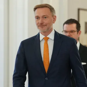 Ein Mann im Anzug (Lindner) verlässt ein Gebäude