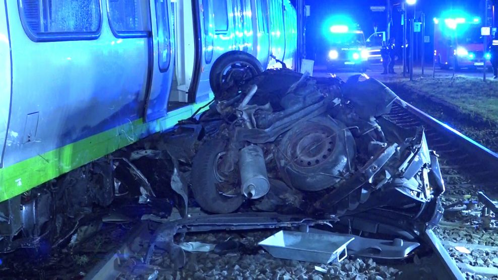 Ein schwer demoliertes Auto auf den Bahngleisen