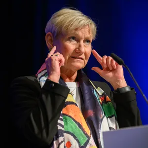 Eine Frau mit einem bunten Schal am Rednerpult