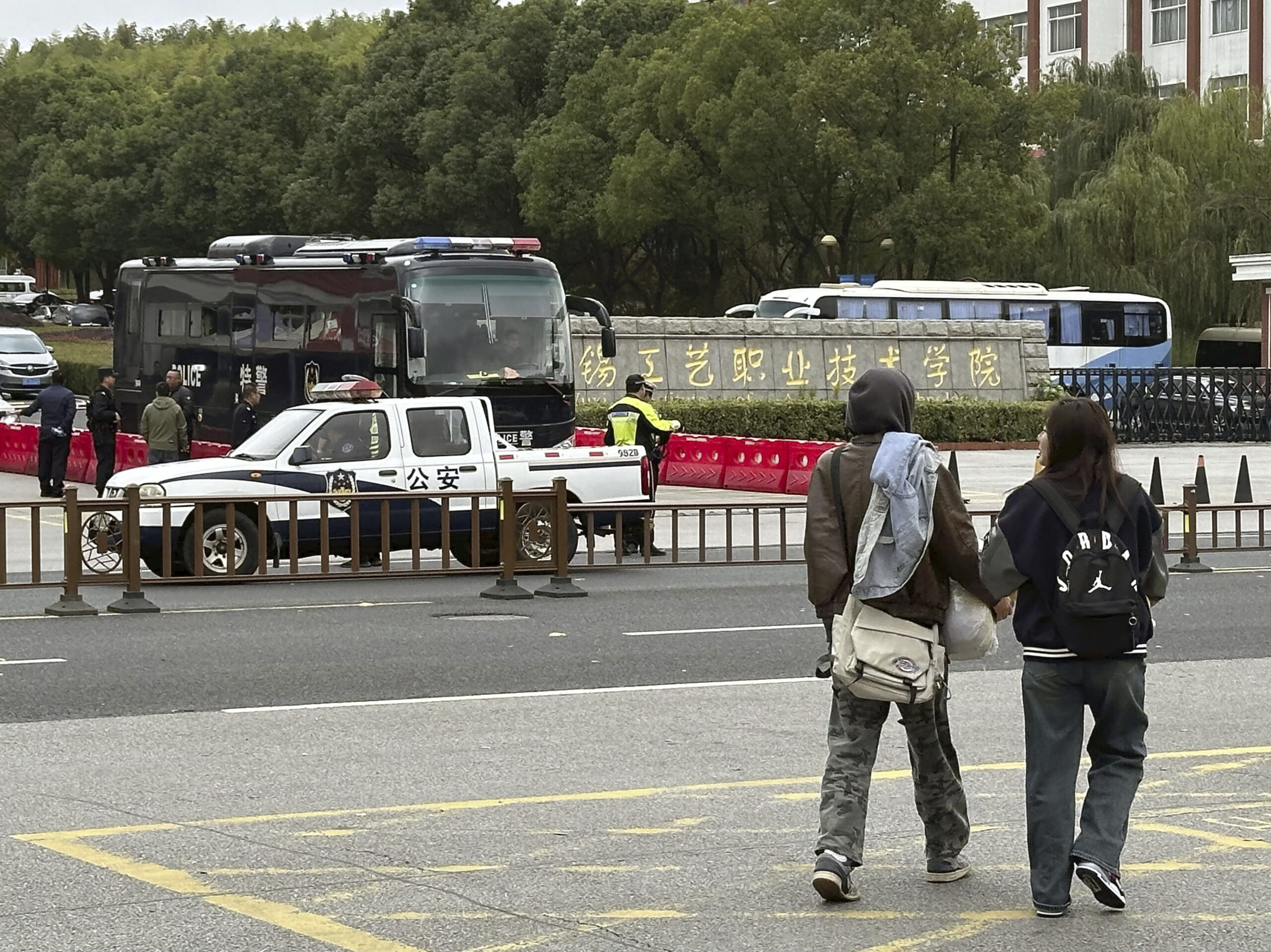 Polizeifahrzeuge stehen vor dem Wuxi Vocational Institute of Arts and Technology, wo ein Mann bei einem Messerangriff mindestens acht Menschen getötet und weitere 17 Personen verletzt hat.