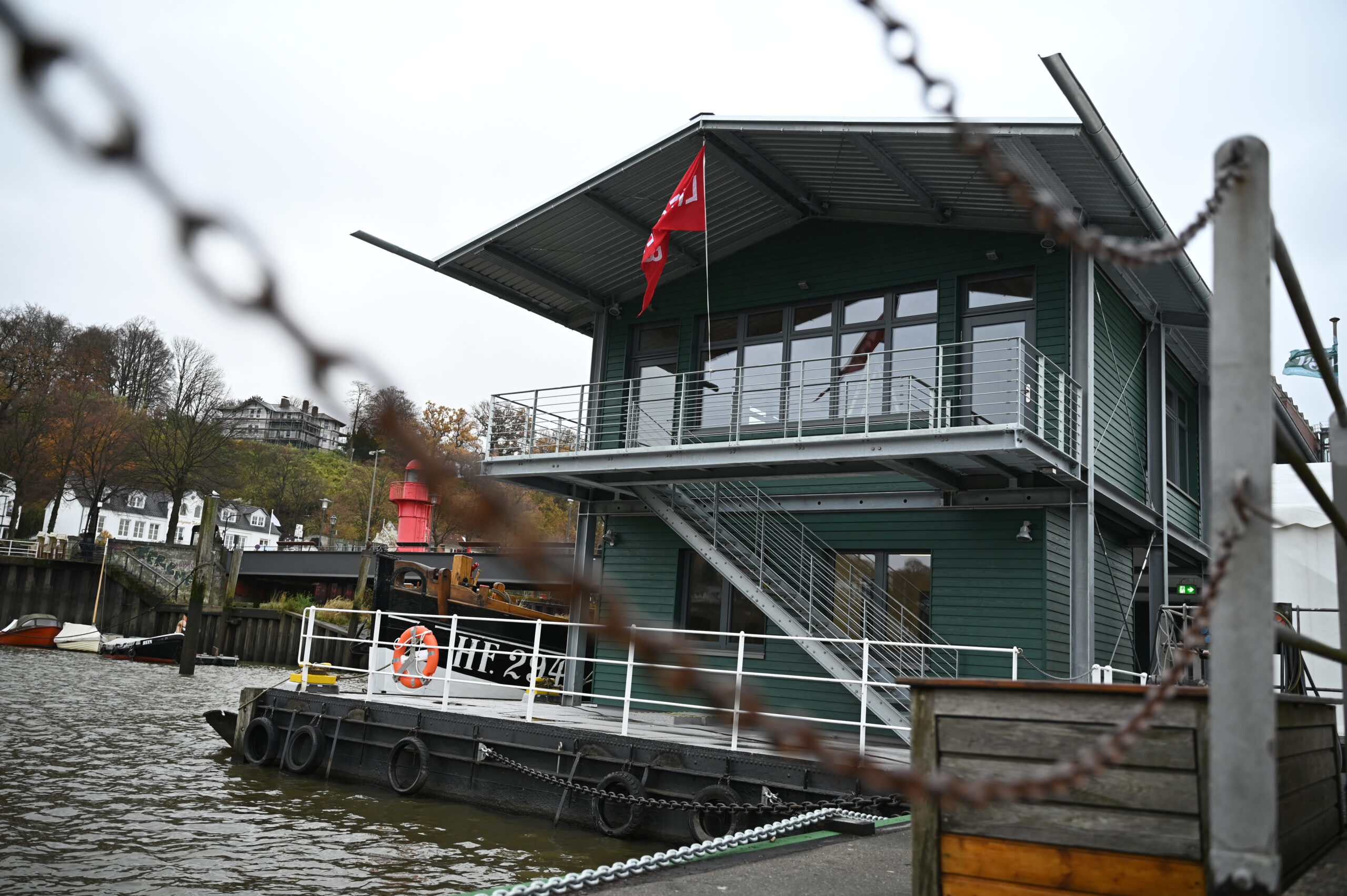 Das Besucherzentrum ist hinter einem Geländer zu sehen. Das neue Gebäude am Museumshafen Oevelgönne ist alten Hafenliegern nachempfunden und soll zukünftig als Besucher- und Informationszentrum über die historischen Schiffe und die Arbeit des Vereins informieren.