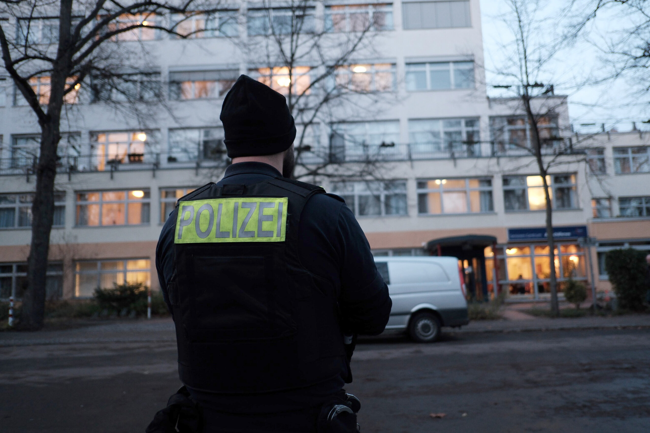 Ein Polizist steht vor einem Pflegeheim.