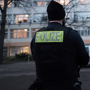 Ein Polizist steht vor einem Pflegeheim.