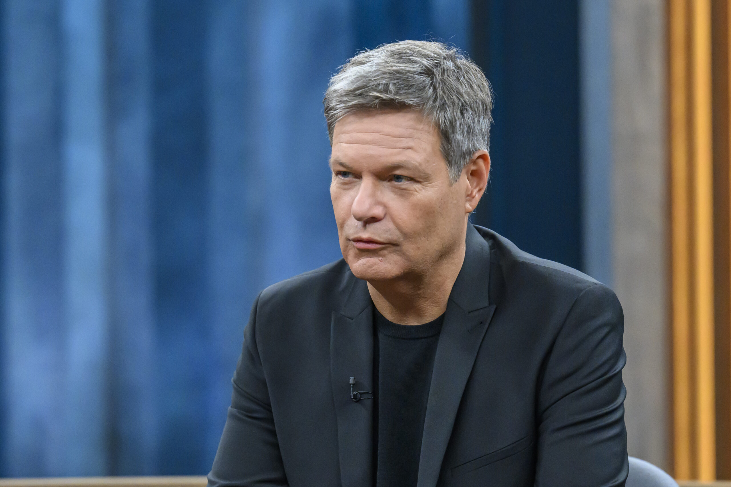 Ein Mann (Robert Habeck) sitzt im Anzug in einem Fernsehstudio