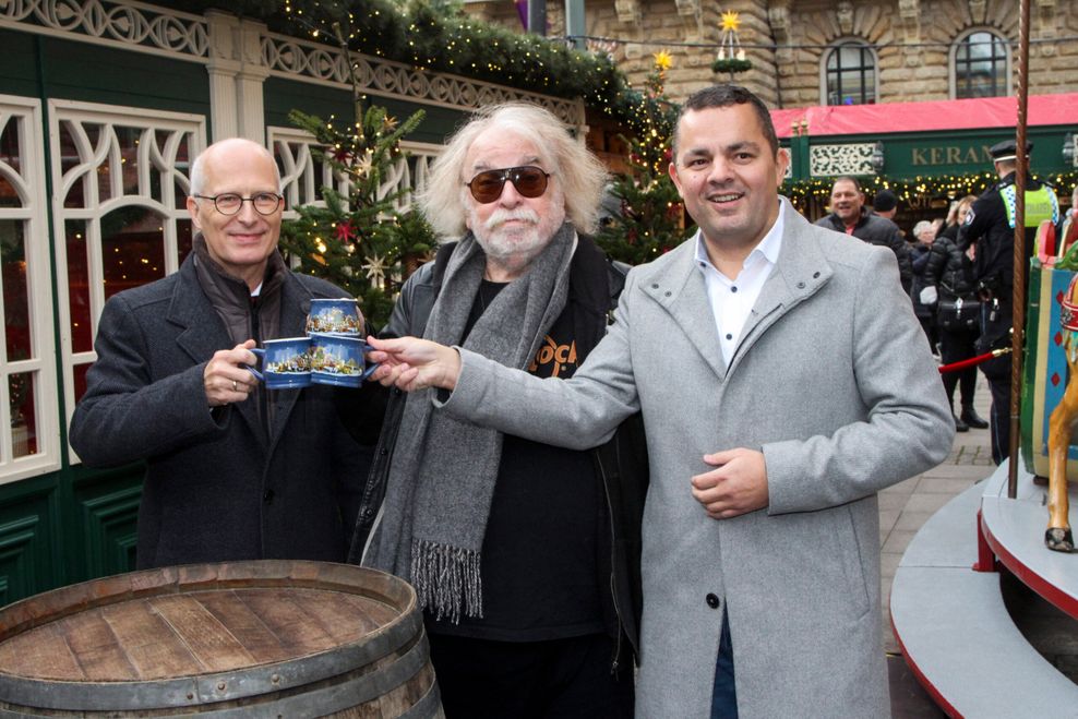 Peter Tschentscher (SPD), Hamburgs Erster Bürgermeister, Roncalli-Legende Bernhard Paul und Ralf Neubauer (SPD), Bezirksamtsleiter des Bezirks Hamburg-Mitte halten jeweils eine Tasse Glühwein in der Hand.