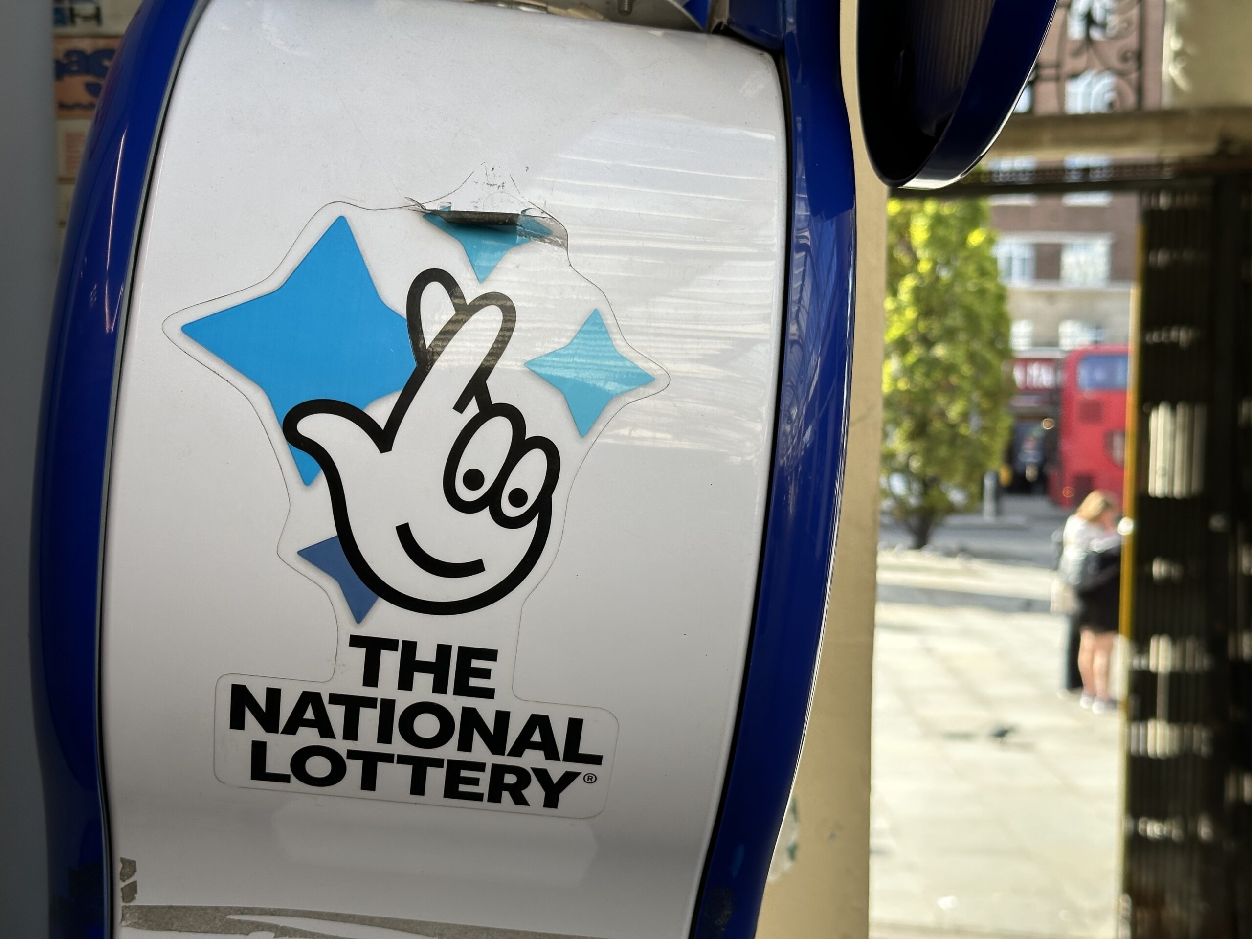 Das Logo der National Lottery ist an einem Kiosk zu sehen.