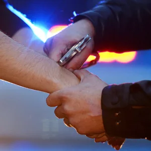 Einem Mann werden Handschellen angelegt (Symbolfoto)