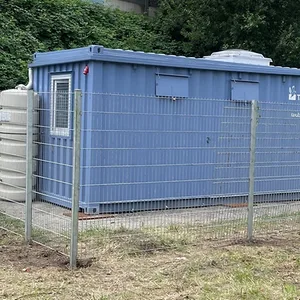 Ein blauer Container umringt von einem Zaun
